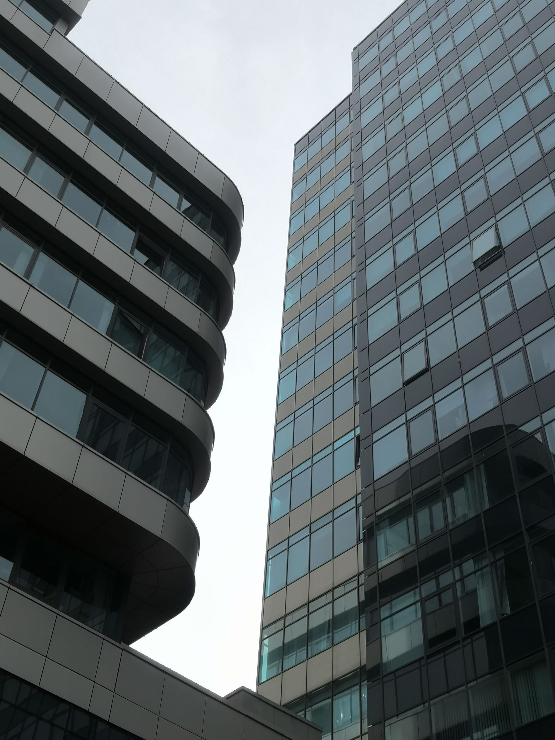 Architectural view of tall modern glass buildings in a city environment.